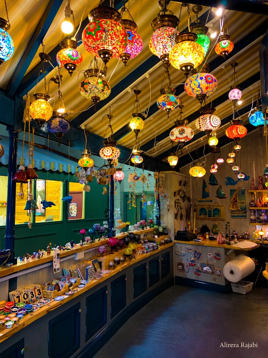 A warmly lit interior filled with colourful hanging lamps
