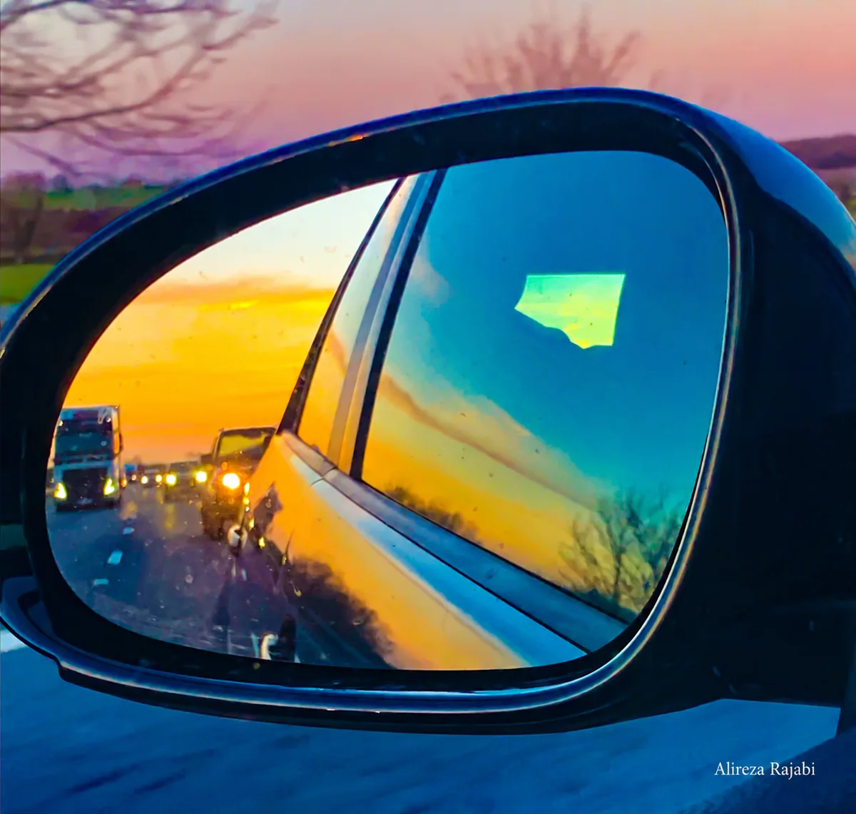 A car mirror reflecting golden evening light