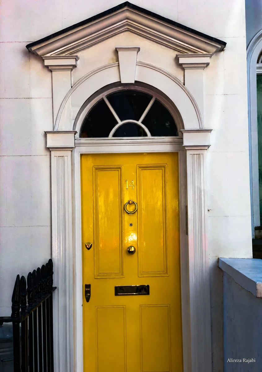 A yellow door framed by a pale architectural facade
