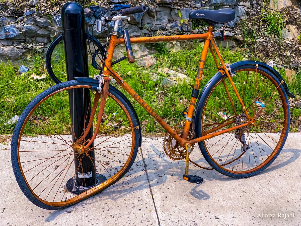 A colourful bicycle leaning against a railing