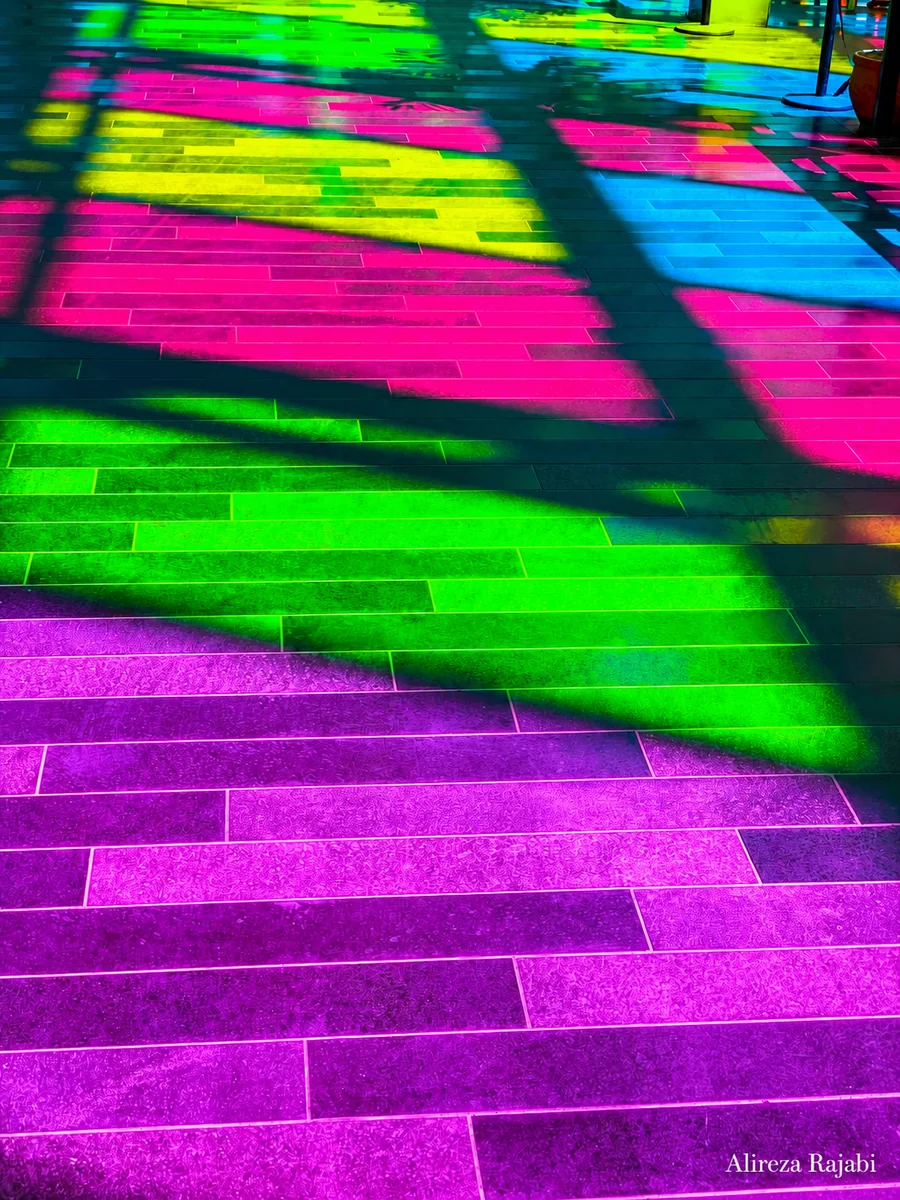 Coloured light falling across a tiled floor
