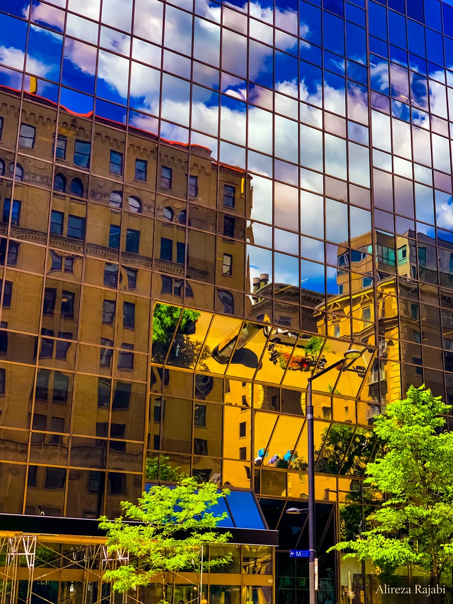 A building reflected in a mirrored glass facade